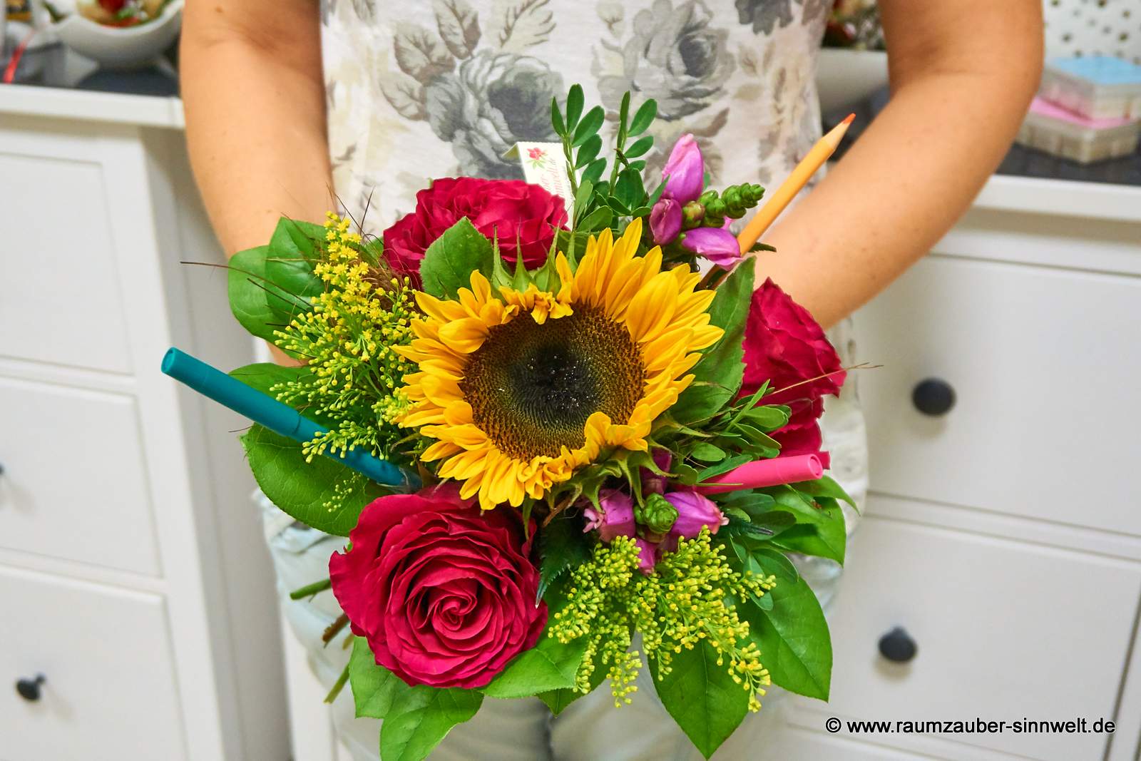 Rundstrauß aus Sonnenblume, Rosen, Chelone und Solidago mit Stiften für den Schulanfang